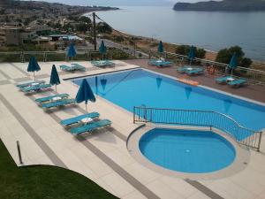 a large swimming pool with chairs and umbrellas at Renieris Hotel in Stalos