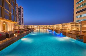 ein Hotelpool mit Stühlen und ein Gebäude in der Unterkunft Media One Hotel in Dubai