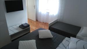 a small room with a bed and a television at Rooms Ive in Lozovac