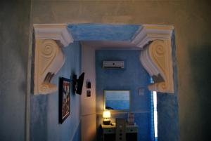 BolognettaにあるOleaster - Bolognettaの青い壁の廊下、窓が備わる客室です。