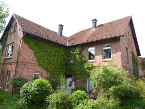 a brick building with ivy on the side of it at Freizeithof Hildesheimer Börde in Holle