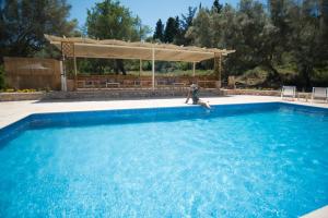 un uomo è seduto in una grande piscina di Gea Villas a Lygia