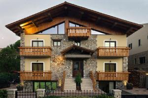a house with wooden balconies on top of it at Alpine Aria in Kalavrita