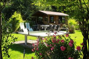 un jardín con mesa, sillas y cenador en Hotel Garni Elegant, en Willingen