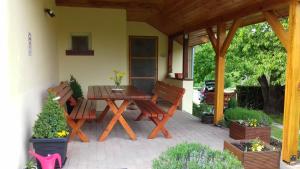 a wooden table and chairs on a patio at Boglárka Vendégház in Vasvár