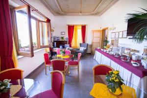 ein Esszimmer mit Tischen, Stühlen und Fenstern in der Unterkunft Villa Margherita in Cefalú