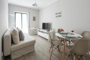 uma sala de estar branca com um sofá e uma mesa em Aveiro Train Flat em Aveiro