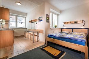 a bedroom with a bed and a table and a kitchen at ALMET apartmánové štúdio 206 in Donovaly