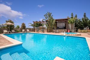 een groot zwembad met blauw water bij Areti Suites in Kathiana
