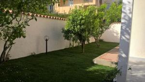 アルゲーロにあるVilla Paolaの白壁の木々の庭