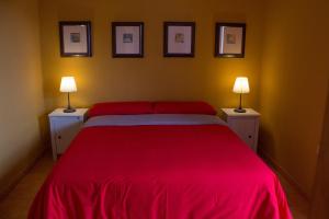 1 dormitorio con 1 cama grande de color rojo y 2 mesitas de noche en Apartamento Salinas 2, en Los Cancajos