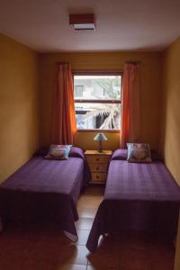 2 Betten in einem kleinen Zimmer mit Fenster in der Unterkunft Apartamento Salinas 2 in Los Cancajos