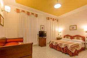 a hotel room with two beds and a television at Mariano IV Palace Hotel in Oristano