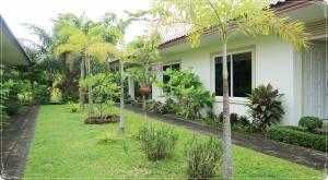 a house with palm trees in the yard at Vacation Garden Villa in Thalang