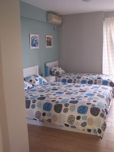ein Schlafzimmer mit einem Bett mit einer Bettdecke und Kissen in der Unterkunft Athenian apartment with garden, near metro station Chalandri Nu 3 in Athen