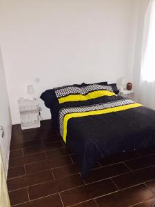 a bedroom with a bed with a yellow and black blanket at T3 proche Castillet in Perpignan