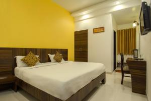 a bedroom with a large bed and a television at Hotel Metropolitan in Jaipur