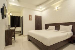 a bedroom with a bed and a desk in it at Hotel Metropolitan in Jaipur