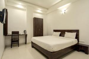 a bedroom with a bed and a television in it at Hotel Metropolitan in Jaipur