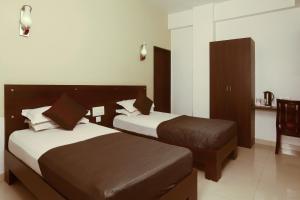 a hotel room with two beds and a table at Hotel Metropolitan in Jaipur
