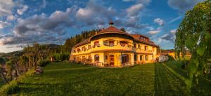 ein großes gelbes Haus auf einem grünen Feld in der Unterkunft Biolandhaus Arche in Eberstein