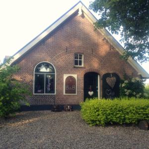 a large brick building with a large window at Bed and Breakfast Klein Groenbergen in Leersum