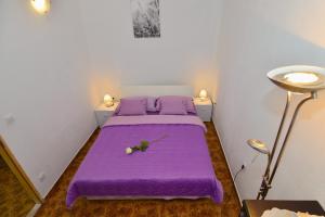 Un dormitorio con una cama morada con un reloj. en Apartments Veky 3, en Split