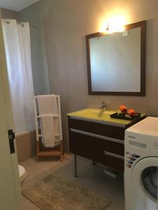 a bathroom with a sink and a washing machine at Apartamento Vilamoura Marina in Vilamoura