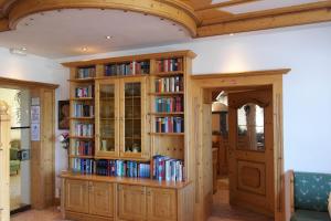 eine Bibliothek mit Bücherregalen aus Holz mit Büchern in der Unterkunft Hotel Habhof - Garni in Seefeld in Tirol