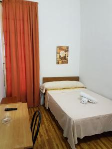 a small room with two beds and a table at Pensión Berti Madrid in Madrid