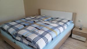 1 cama con edredón azul y blanco en un dormitorio en Ferienwohnung "Am Weinberg", en Bad Schmiedeberg