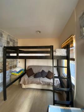 Habitación con cama alta, con baño propio en casa de vecinos dormitorio número 1