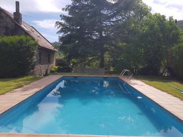 Casa de piedra con piscina, jardín y barbacoa