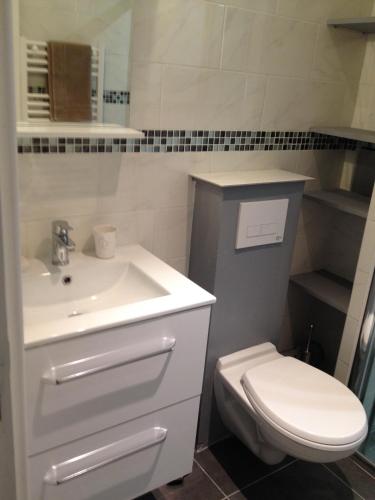 une salle de bain avec un lavabo blanc et des toilettes dans l'établissement K&A Apartment, à Aulnay-sous-Bois