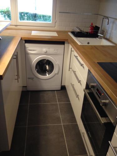 une cuisine avec une machine à laver et un évier dans l'établissement K&A Apartment, à Aulnay-sous-Bois