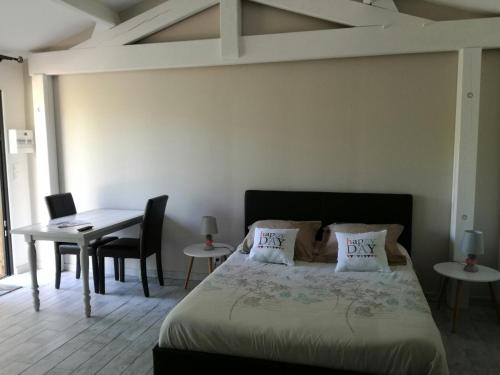 1 dormitorio con 1 cama, mesa y sillas en Le Domaine d'Azae, en Gujan-Mestras