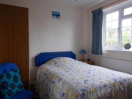 a bedroom with a blue bed and a blue chair at Arden Lodge in Oxford