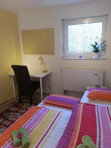 two beds in a room with a desk and a window at Fewo Near Rheinfall in Jestetten