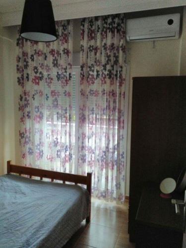ネア・ペラモスにあるDespina's Residenceのベッドルーム1室(ベッド1台付)、窓(カーテン付)