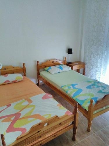ein Schlafzimmer mit 2 Betten und einem Tisch mit einer Lampe in der Unterkunft Despina's Residence in Néa Péramos