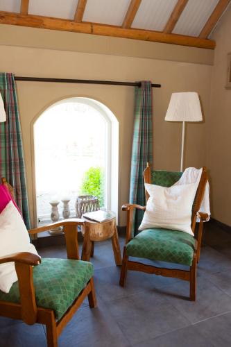 a living room with two chairs and a window at Bed and Breakfast Klein Groenbergen in Leersum