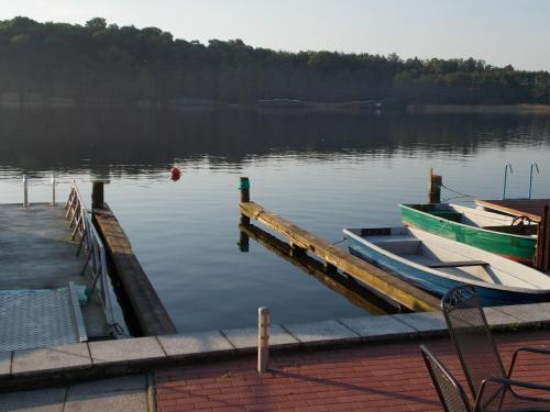 un bateau est amarré à un quai sur un lac dans l'établissement Urlaub am Malchower See - Wassergrundstück, à Malchow