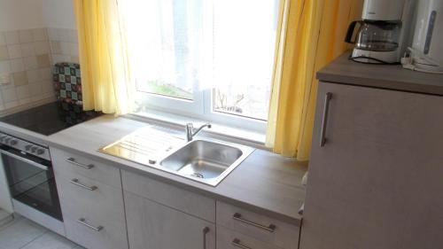 a kitchen with a sink and a window at Urlaub am Malchower See - Wassergrundstück in Malchow