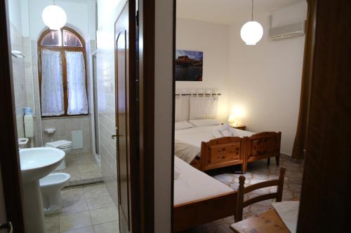 - Baño con dormitorio con cama y lavamanos en Antica Pensione Pinna en Castelsardo