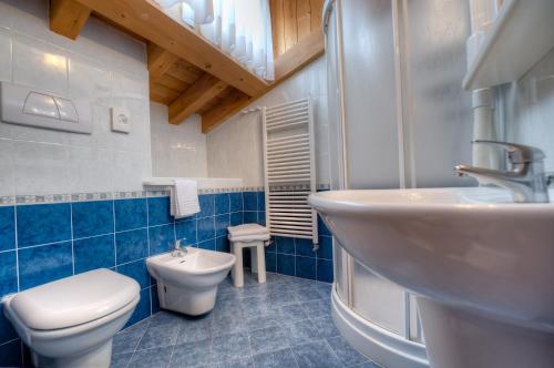 a blue bathroom with a toilet and a sink at Hotel Kennedy in Lido di Jesolo