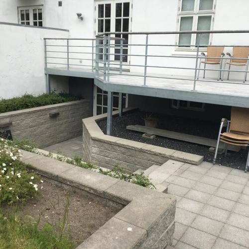 a building with a balcony and chairs on a patio at Casa Aurora in Aalborg