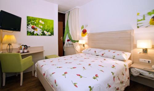 a bedroom with a bed and a desk and a television at Schifferkrug Hotel & Weinstube in Celle