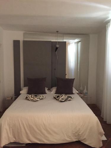 a white bed with two pillows on top of it at A Ca Du Barba Ge in Vallebona