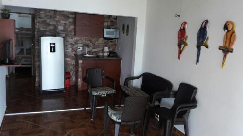 a living room with chairs and a refrigerator at Casa Madrigueña in Rincón