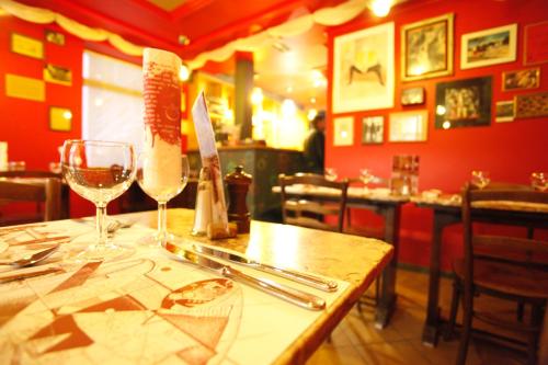Hotel O Mal Aime في ستافيلو: طاولة في مطعم مع كؤوس النبيذ عليه